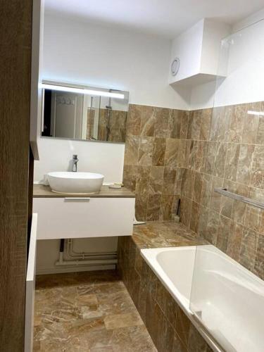 une salle de bain avec un lavabo et une baignoire et un lavabo dans l'établissement Bienvenue au Green, à Neufchâtel-Hardelot