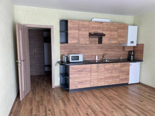 cocina con fregadero y microondas en Yellow apartments en Boryspilʼ