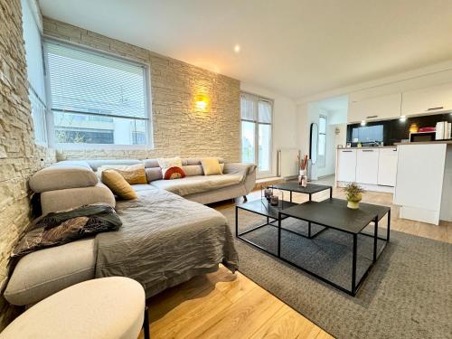 a living room with a couch and a table at Exceptionnel ! T3 de standing - Rooftop - Jacuzzi in Lorient