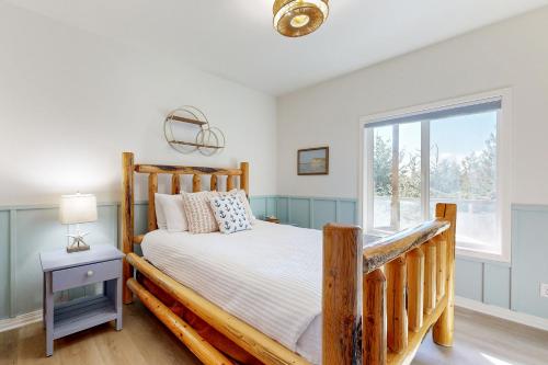 a bedroom with a wooden bed and a window at The Beach Bunkhouse in Pacific City