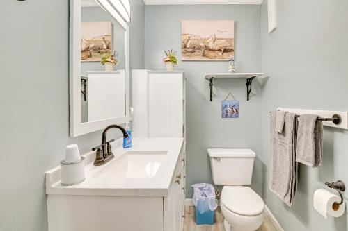 a bathroom with a sink and a toilet and a mirror at Coastal Condo on Beach with Community Pool Access! in Myrtle Beach