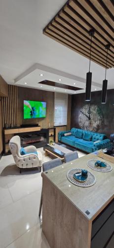 a living room with a couch and a tv at Design Apartment PLATINIUM SPA LUX 5 STAR "HAVANA" Completely PRIVATE Wellness & Spa FREE INCLUDED Sauna & Jacuzzi & Salt Wall & Fire place & 3D Ceilings & Business WiFi & NETFLIX & Keyless code entry & FULL SMART APP & SECURE 2 Parking place in Ćuprija