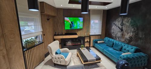 a living room with a blue couch and a tv at Design Apartment PLATINIUM SPA LUX 5 STAR "HAVANA" Completely PRIVATE Wellness & Spa FREE INCLUDED Sauna & Jacuzzi & Salt Wall & Fire place & 3D Ceilings & Business WiFi & NETFLIX & Keyless code entry & FULL SMART APP & SECURE 2 Parking place in Ćuprija