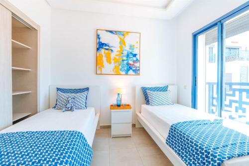twee bedden in een kamer met een raam bij Residence Costa-Mar in Martil