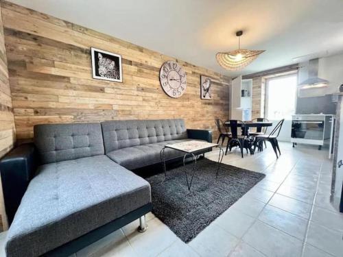 un salon avec un canapé et une salle à manger dans l'établissement La P'tite maison Les Tourelles, à Caffiers