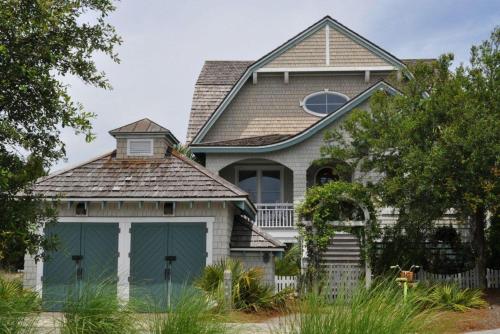 a large house with a green garage at Journeys End in Southport