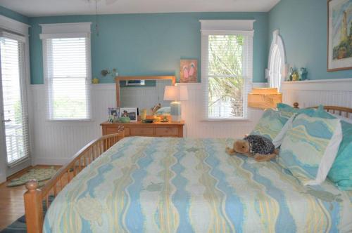 a teddy bear laying on a bed in a bedroom at Journeys End in Southport