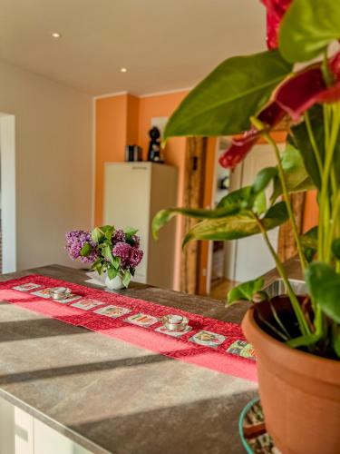 a kitchen counter with a table with flowers on it at Insel-Hof Reichenau Hotel-garni in Reichenau