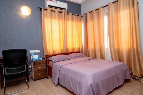 a bedroom with a bed and a desk and a chair at Studio cosy et agréable in Lomé