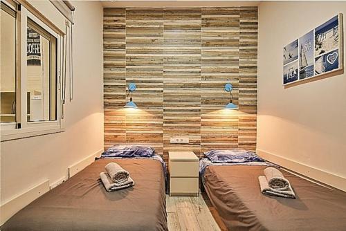 2 Betten in einem Zimmer mit Holzwänden in der Unterkunft The Sailors House Ha in Cádiz