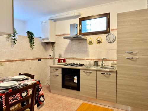 a kitchen with a sink and a tv on the wall at A Casa di Anto - 90 mq con parcheggio interno Animal friendly in Infernetto