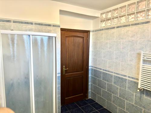 a bathroom with a shower and a glass door at A Casa di Anto - 90 mq con parcheggio interno Animal friendly in Infernetto