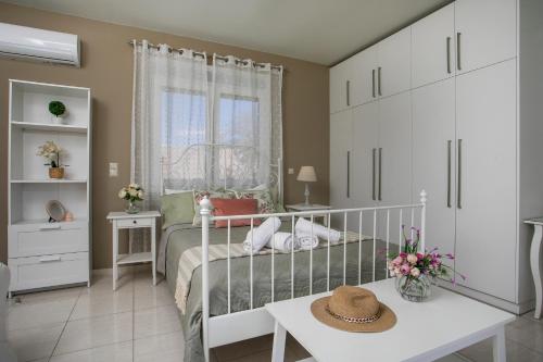 a bedroom with a bed and a table with a hat on it at Sea Breeze & Nature villa ,near the sea, luxury jagguzi and spa private garden in Kremasti
