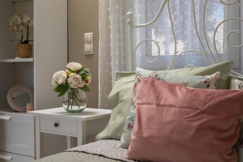 a bedroom with a bed with a vase of flowers at Sea Breeze & Nature villa ,near the sea, luxury jagguzi and spa private garden in Kremasti