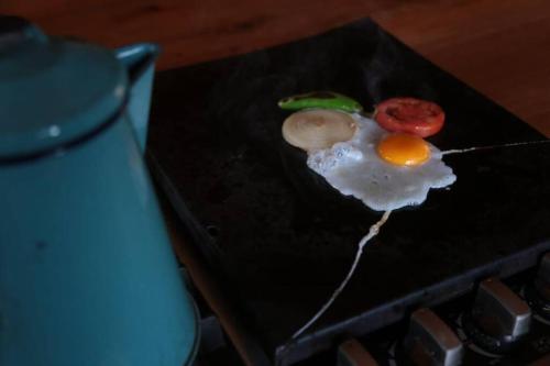 un huevo frito con un tomate en una parrilla en Cabaña Los Hernández, en Arteaga