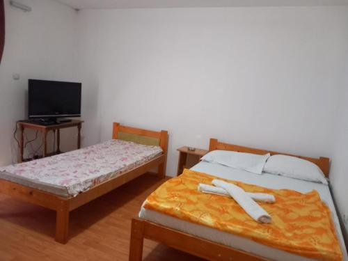a bedroom with two beds and a tv at Hostel Wien in Novi Pazar