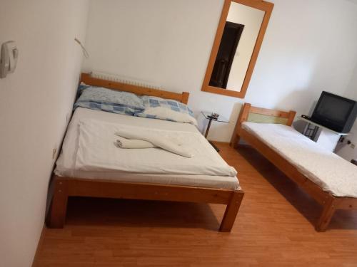 a bedroom with two beds and a mirror and a tv at Hostel Wien in Novi Pazar