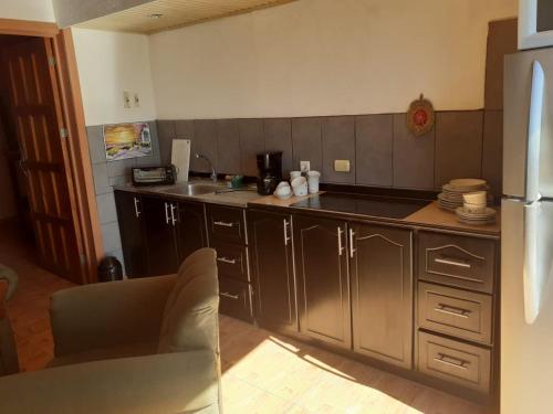 eine Küche mit Holzschränken und einer Arbeitsplatte in der Unterkunft Apartamentos don christian in Grecia