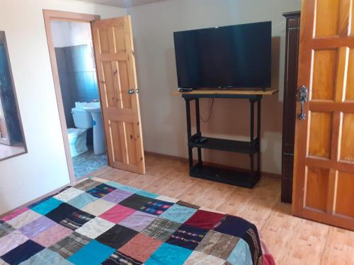Zimmer mit einem Bett und einem TV auf dem Tisch in der Unterkunft Apartamentos don christian in Grecia