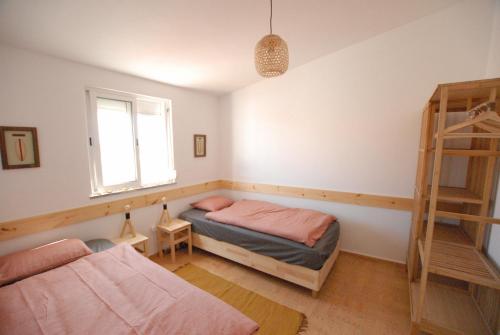1 dormitorio con 2 camas y ventana en Happy Hostel Sagres, en Raposeira