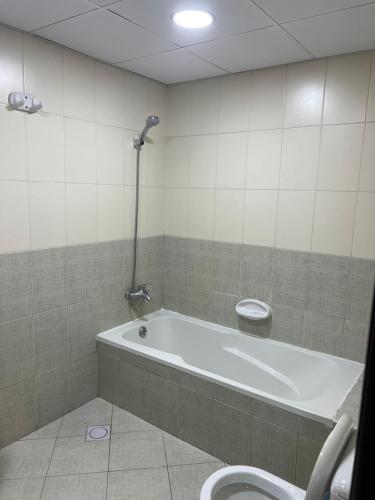 a bathroom with a bath tub and a toilet at R2)Sweet Home fantastic city and sea view at beachإطلالة رائعة على المدينة والبحر على الشاطئ in Ajman 