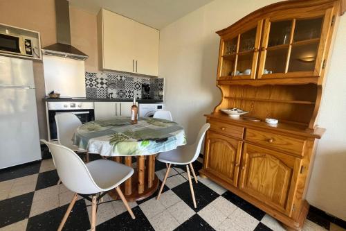 une cuisine avec une table et des chaises dans une cuisine dans l'établissement Charming apartment overlooking the sea, à Port-la-Nouvelle