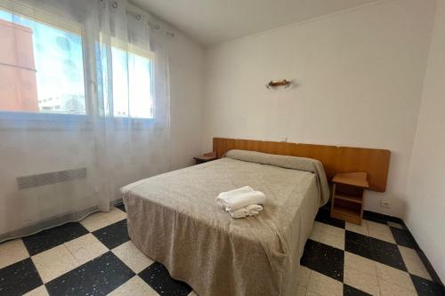 une chambre avec un lit avec deux serviettes dessus dans l'établissement Charming apartment overlooking the sea, à Port-la-Nouvelle