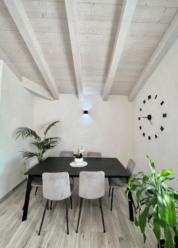 a dining room with a table and chairs and a clock at Terme Apartment Levico in Levico Terme