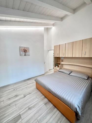 una camera con un grande letto e pavimenti in legno di Terme Apartment Levico a Levico Terme