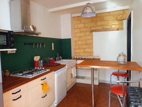 a kitchen with white and green walls and a counter at Appartement cosy 60m², proche gare St Roch et centre. in Montpellier