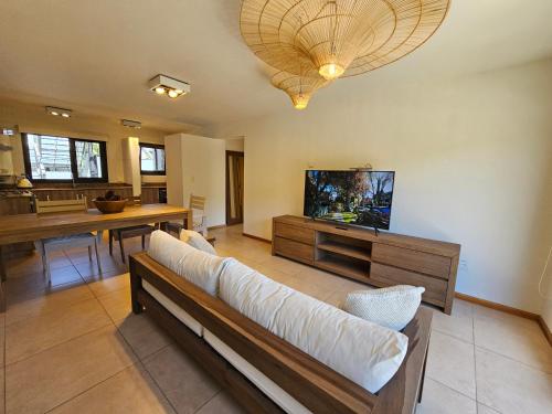 een woonkamer met een bank en een flatscreen-tv bij Andes Apartments / CENTRICOS a ESTRENAR in San Martín de los Andes