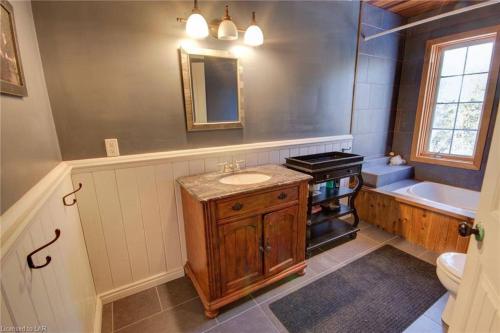 y baño con lavabo, aseo y bañera. en Dingle Run Lodge at Sir Sam's, en Haliburton