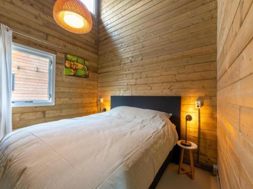 1 dormitorio con 1 cama en una pared de madera en Scilla, en Soesterberg