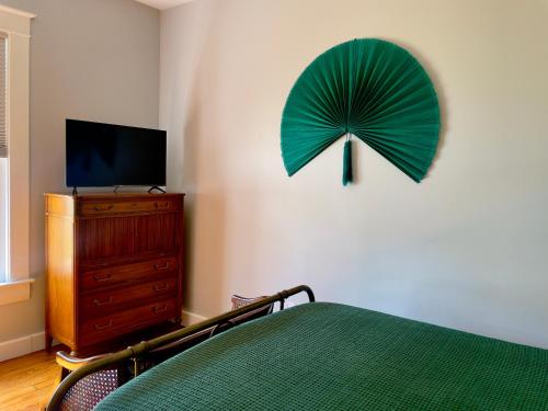 a bedroom with a green fan on the wall at Tampa Heights Bungalow in Tampa