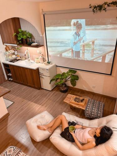 a woman laying on a couch in a living room at Cine Homestay - Căn hộ cao cấp Ecopark Hải Dương in Hải Dương