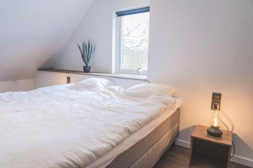 a bedroom with a large white bed with a window at Tegelvillan på golfbanan in Oxie