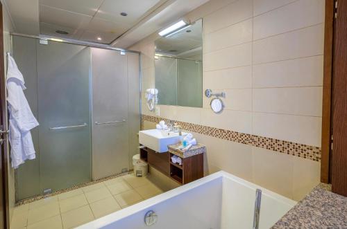 ein Bad mit einer Badewanne, einem Waschbecken und einer Dusche in der Unterkunft Luxury apartment Rafal Tower شقة فاخرة برج رافال in Riad