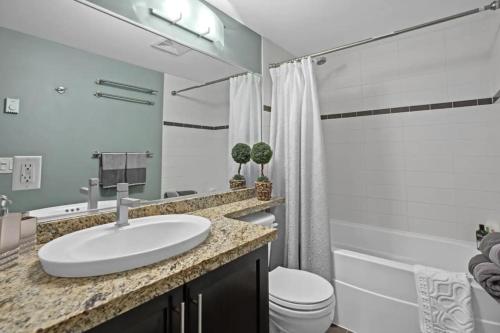 Baño blanco con lavabo y aseo en Luxury Designer Condo In The Heart Of Downtown - Best Location!, en Vancouver