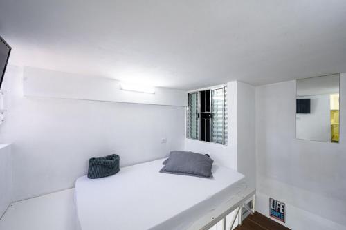 um quarto branco com um banco branco em 46 LOFT TRIPLO · Mini apartamento em Metrô Jabaquara e EXPO em São Paulo