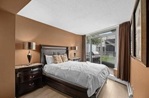 a bedroom with a large bed and a window at Luxury Designer Condo In The Heart Of Downtown - Best Location! in Vancouver