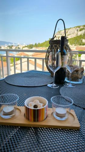 uma mesa com um prato de comida e um copo de vinho em Apartman Ivana em Klek