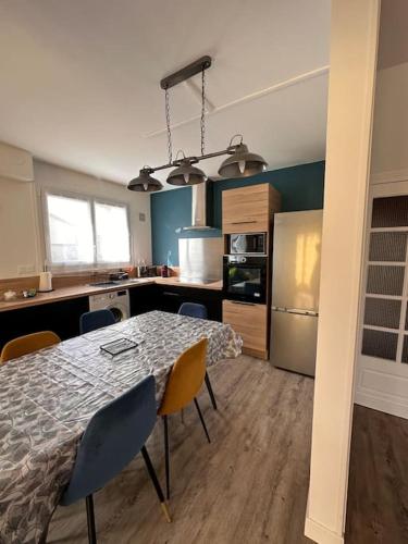 une cuisine avec une table et des chaises dans une pièce dans l'établissement Agréable maison de ville 6 personnes, à Bourges