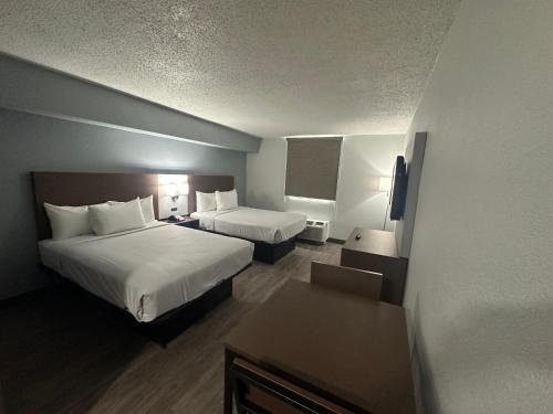 a hotel room with two beds and a television at Suburban Studios Chester I-95 in Chester