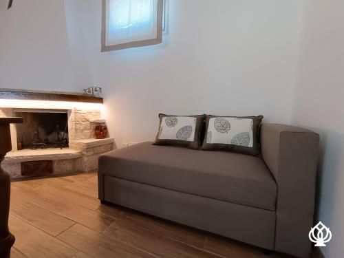 um sofá numa sala de estar com lareira em La Casa sul Poggio-Valle d'Itria em Alberobello