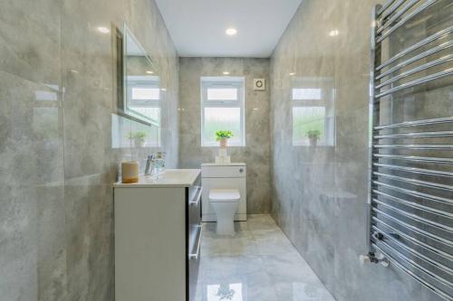 a bathroom with a toilet and a sink and a shower at Hayes Home - Easy links to LHR and London in Northolt
