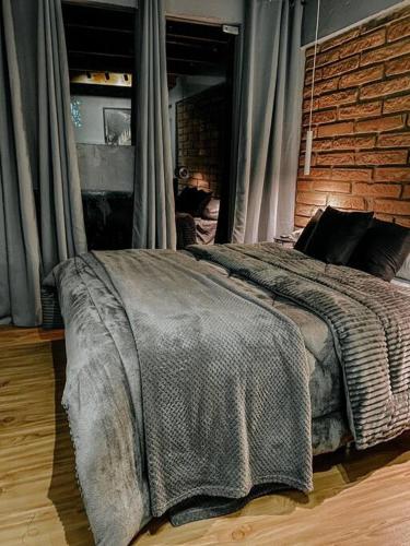 伊格雷日尼亞的住宿－Apto Aventus，一间卧室设有一张带砖墙的大床