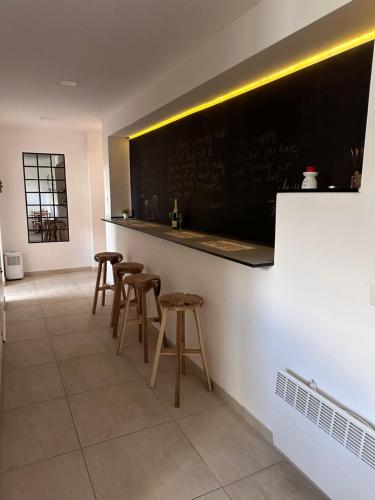 a bar with stools and a chalkboard on a wall at Ravne Energy Apartments in Visoko