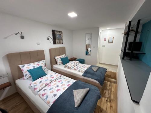 a small room with two beds and a couch at Ravne Energy Apartments in Visoko