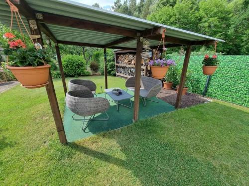 einen Pavillon mit Stühlen und einem Tisch im Hof in der Unterkunft Ferienhaus Muellrose am Wald in Müllrose