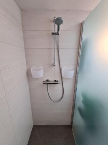 a shower with a shower head in a bathroom at Ferienhaus Müllrose am Wald in Müllrose